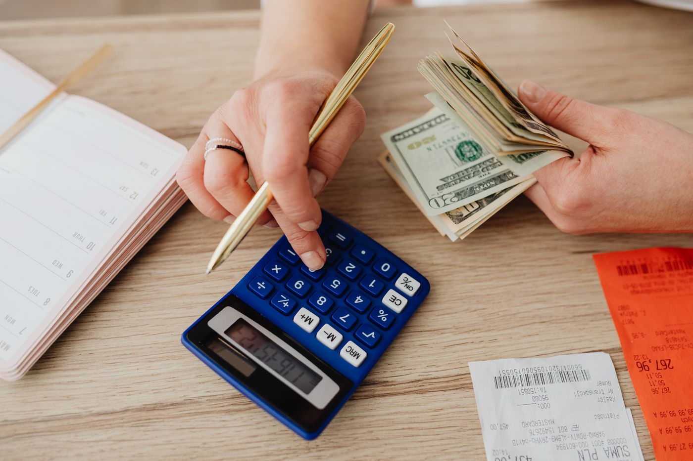 Hands organizing a household budget with a calculator and receipts